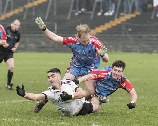 Kilmeena's Keith Joyce is sent sprawling by Keith O'Reilly and Caelom Mulry of Monivea-Abbey Kilmeena's Keith Joyce is sent sprawling by Keith O'Reilly and Caelom Mulry of Monivea-Abbey
