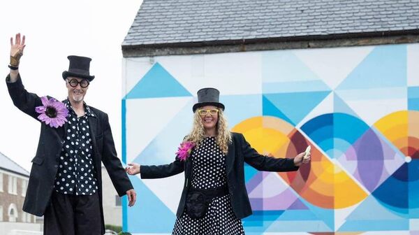 Stilt walkers in front of the mural commissioned for Belmullet 200. Stilt walkers in front of the mural commissioned for Belmullet 200.